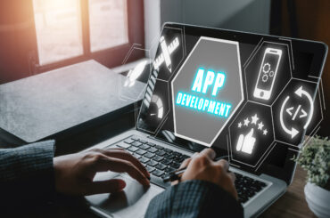 App development concept, Person hand using laptop computer with app development icon on virtual screen background, Designing application for mobile phone.